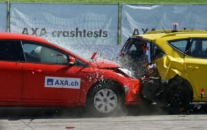 Voitures rouges et jaunes montrées dans une collision frontale lors d'un crash test pour une évaluation de sécurité.