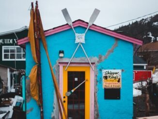 Une boutique bleue et jaune vibrante au milieu de la neige, parfaite pour les voyages et les thèmes hivernaux.