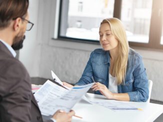 Deux personnes en entretien, un recruteur et une candidate, le CV en ligne pourrait être discuté.
