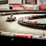 Kart de loisir rouge et blanc prenant un virage sur une piste avec bordures