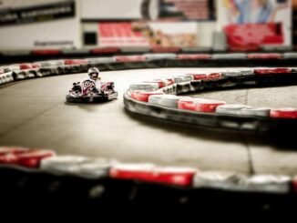 Kart de loisir rouge et blanc prenant un virage sur une piste avec bordures