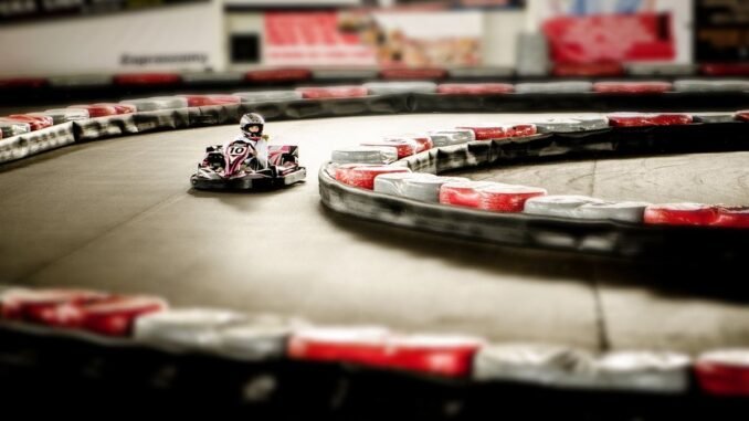 Kart de loisir rouge et blanc prenant un virage sur une piste avec bordures