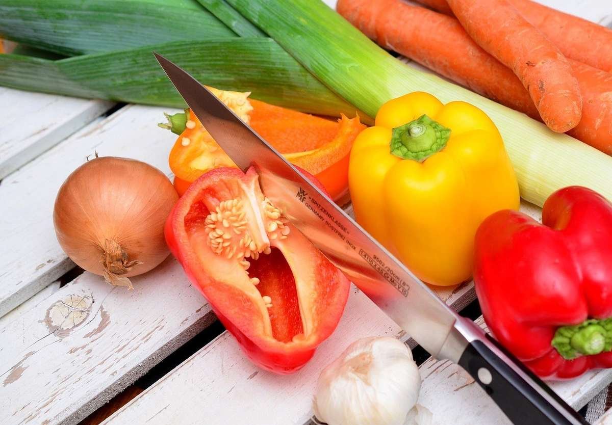 Légumes et fruits sur une table blanche, couteau, activité de préparation culinaire
