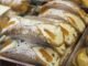 Des cannoli garnis de crème, zestes d'orange et raisins, saupoudrés de sucre
